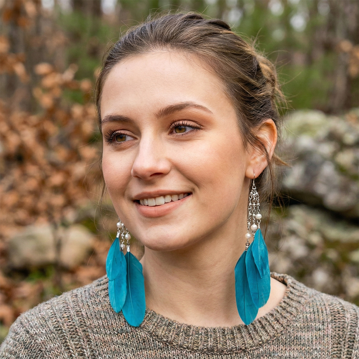 Woman wearing blue feather earrings with a natural background